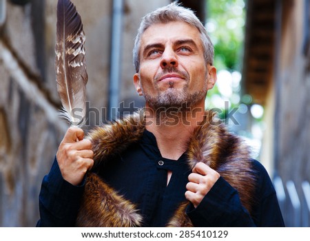 Portrait of a sexy man and wolf furry and eagle feathers, a disgruntled expression on his face