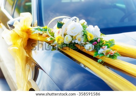 Luxury wedding car decorated with flowers. White flower and ribbons.