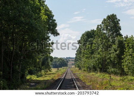 Railway between the cities, forest and fields, on a sunny summer day, germany countryside