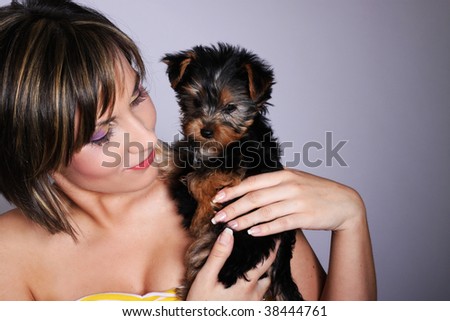 Beautiful woman holding dog on her arms
