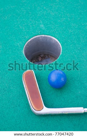 Close up on Miniature Golf objects,  hole,ball and a golf club