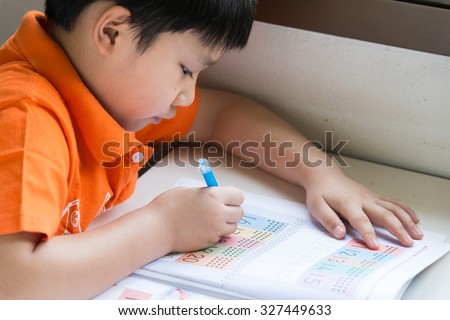Little Boy Writing Math Exercise At Home