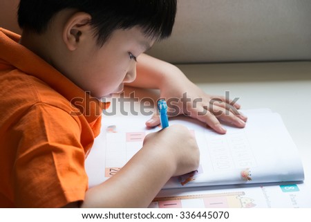 Little Boy Writing Math Exercise At Home