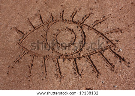 outline of eye - drawn on sand on a beach