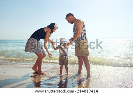 Happy young family spending time on the sea. Sunny summer day