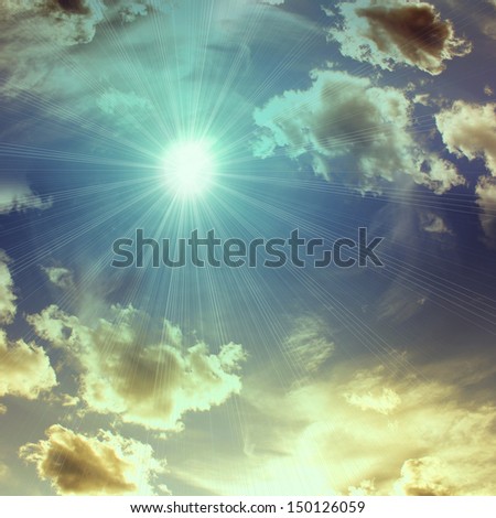 sky blue background with sun rays and silhouette yellow clouds at sunset