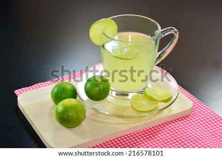 Lemon juice, Lime juice and lime on black wooden table.