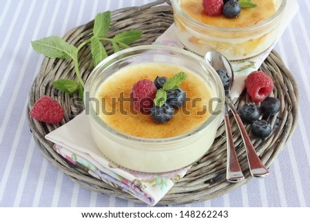 Creme brulee with berries on the lilac background