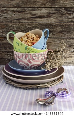 Granola in the   cap and spoons on the lilac background