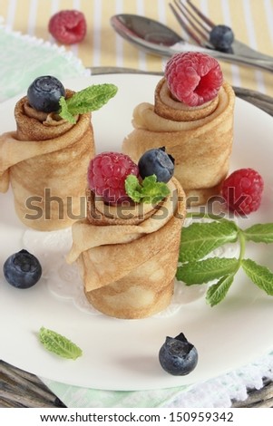 Crepe with berries and mint on the white plate