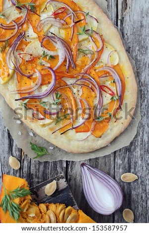 Pizza with pumpkin , apple and onion on wooden background