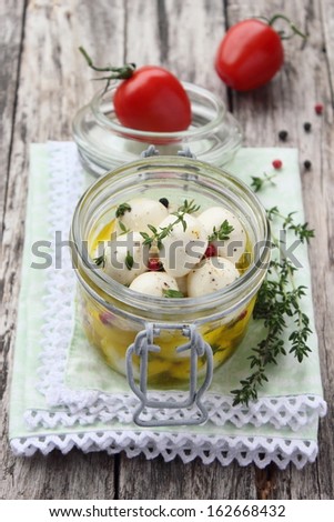 In olive oil marinated mozzarella with thyme, pepper and tomato