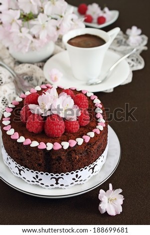 Delicious homemade chocolate cake decorated with raspberries and flowers