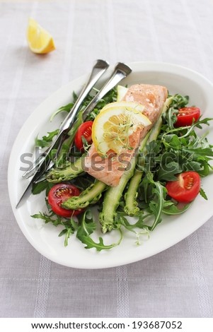 Portion steam salmon with a salad of arugula and fresh asparagus