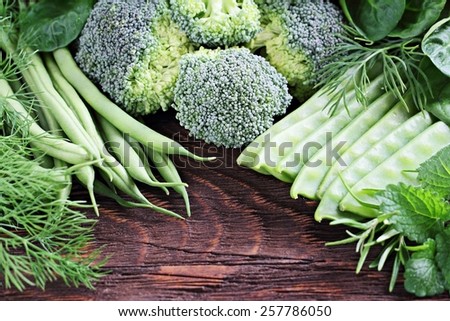 Green vegetables and herbs on a rustic wooden table.Healthy lifestyle.Selective focus.