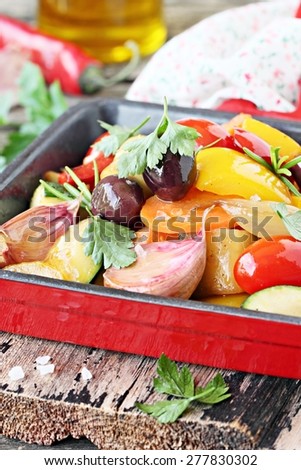 Portion of roasted vegetable ( ratatouille ) on a rustic wooden table. Selective focus.