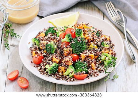 Quinoa salad with broccoli,sweet potatoes and tomatoes on a rustic wooden table.Superfoods concept.Selective focus.