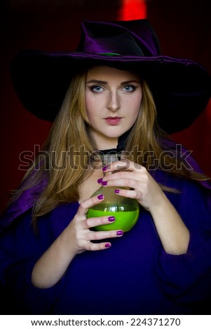 The witch the witch in purple cloak and a hat with a magic potion for halloween