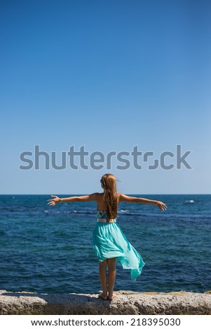 young female standing at the port, near by the blue sea with back,freedom
