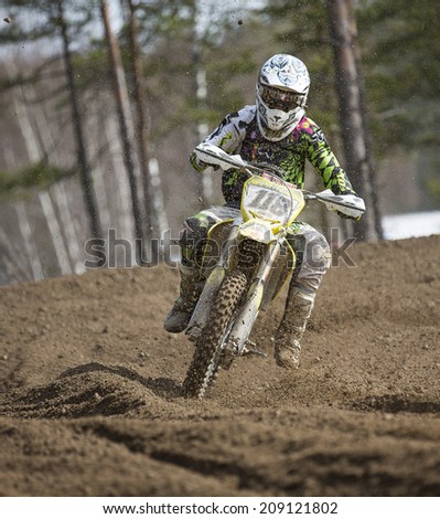 LAITILA, FINLAND - APRIL 20: A motocross driver curves fast in a dirt track . Image taken in West Cross Weekend championships in Laitila, Finland in April 20th 2014.