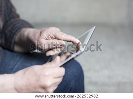 An older man using a tablet.