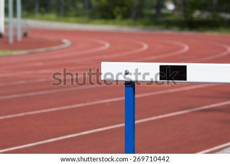 An image of a training hurdles in sunlight on a red surface.