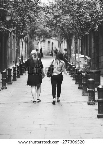 Friends walking in the streets of Barcelona. Image in black and white.