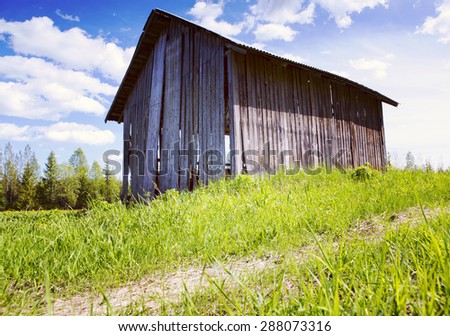 An old barn in the countryside. Image taken in a sunny day in Finland. Image has a strong instagram effect.
