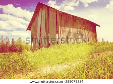 An old barn in the countryside. Image taken in a sunny day in Finland. Image has a strong instagram effect.