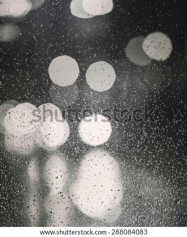 City lights after the rain. Image shot against a clear glass. Image also has an instagram and vintage effect.