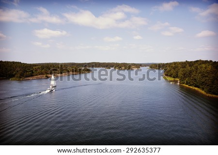 A couple of boats heading to the open sea. Image is taken high above from the bridge. Image is also taken in Finland and has a vintage effect.
