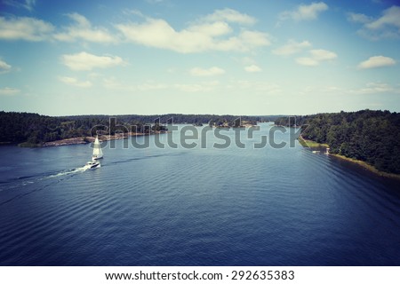 A couple of boats heading to the open sea. Image is taken high above from the bridge. Image is also taken in Finland and has a vintage effect.