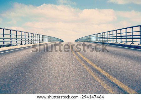 A road to heaven. Image of a bridge going to the sky with clouds. Image has a vintage effect to give an artistic flavor.
