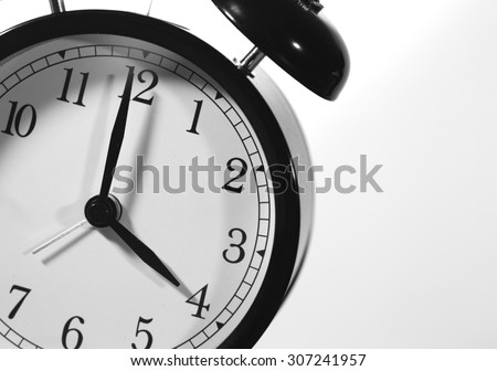 It\'s four o\'clock. An image of a big clock pointing at four o\'clock am or pm. Image has a strong black and white effect applied and image is taken in an angle.