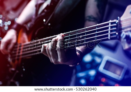 Guitar neck close-up on a concert of rock music in the hands of a musician