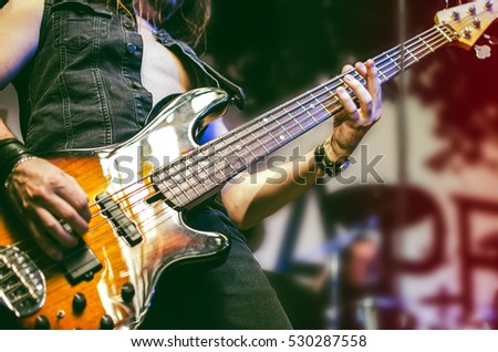 Guitar neck close-up on a concert of rock music in the hands of a musician. guitarist player