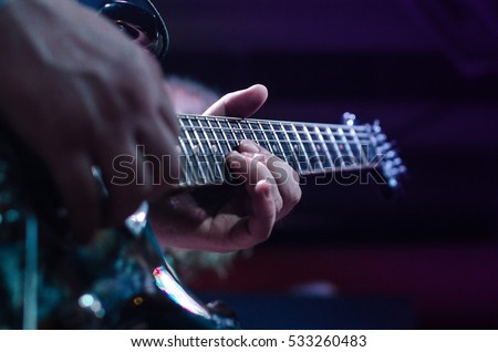 Guitar neck close-up on a concert of rock music in the hands of a musician. guitarist musician