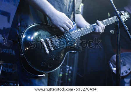 Guitar neck close-up on a concert of rock music in the hands of a musician. musician guitarist player