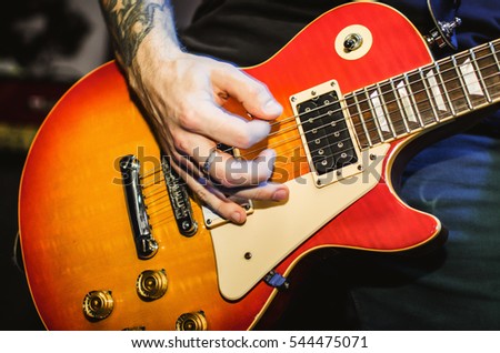 Musician. Blurred hands on guitar string guitar closeup. Live rock music concert.
