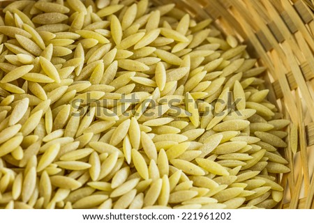 Orzo or risoni on a woven basket. Orzo is a form of short-cut pasta, shaped like a large grain of rice.