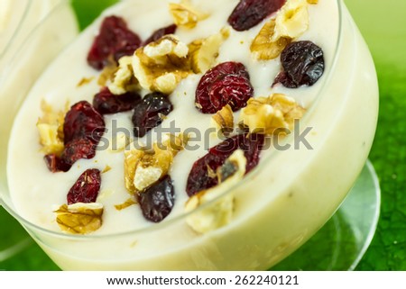 Banana smoothie with crushed walnuts and dried cherries on top
