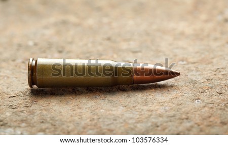 Close-up of kalashnikov bullet on rusted iron plate