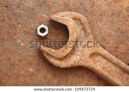 New small screw nut and old grunge wrench - age and size contrast, opposition concept