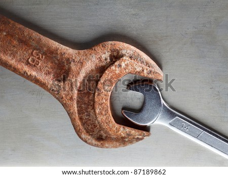Wrenches over metal plate - age and size contrast, opposition concept