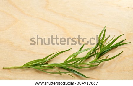 Fresh tarragon macro over wooden chopping board background