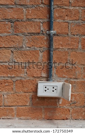 cable and electric plug on brick wall