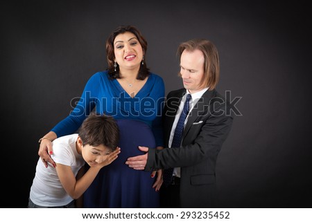 Beautiful family doing different expressions in different sets of clothes: listening to the baby