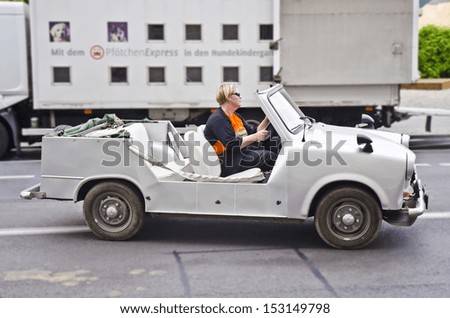 BERLIN - JUNE 13: a tourist drives a vintage East German car on June 13, 2013 in Berlin, Germany. East Germany existed between 1949 and 1990 and produced an average of 200,000 cars pa in the 1980s.