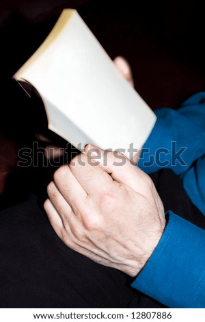 Male hands reading a book (blank page)