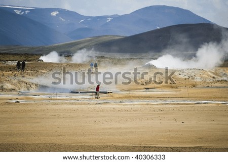 KRAFLA, ICELAND - JUNE 12, 2008: Tourists observe volcanic activity on June 12, 2008 by Krafla, north-east Iceland. Tourists visit Krafla to see the natural beauty and volcanic activity in the area.